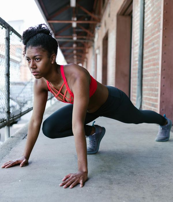 A woman performing a powerful and balanced bodyweight movement.